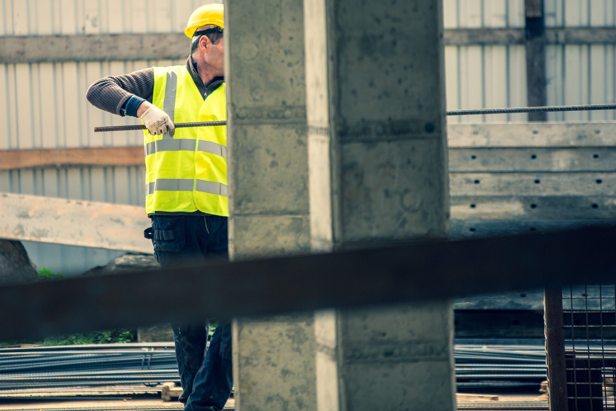 Bauarbeiter mit Weste und Helm auf einer Baustelle