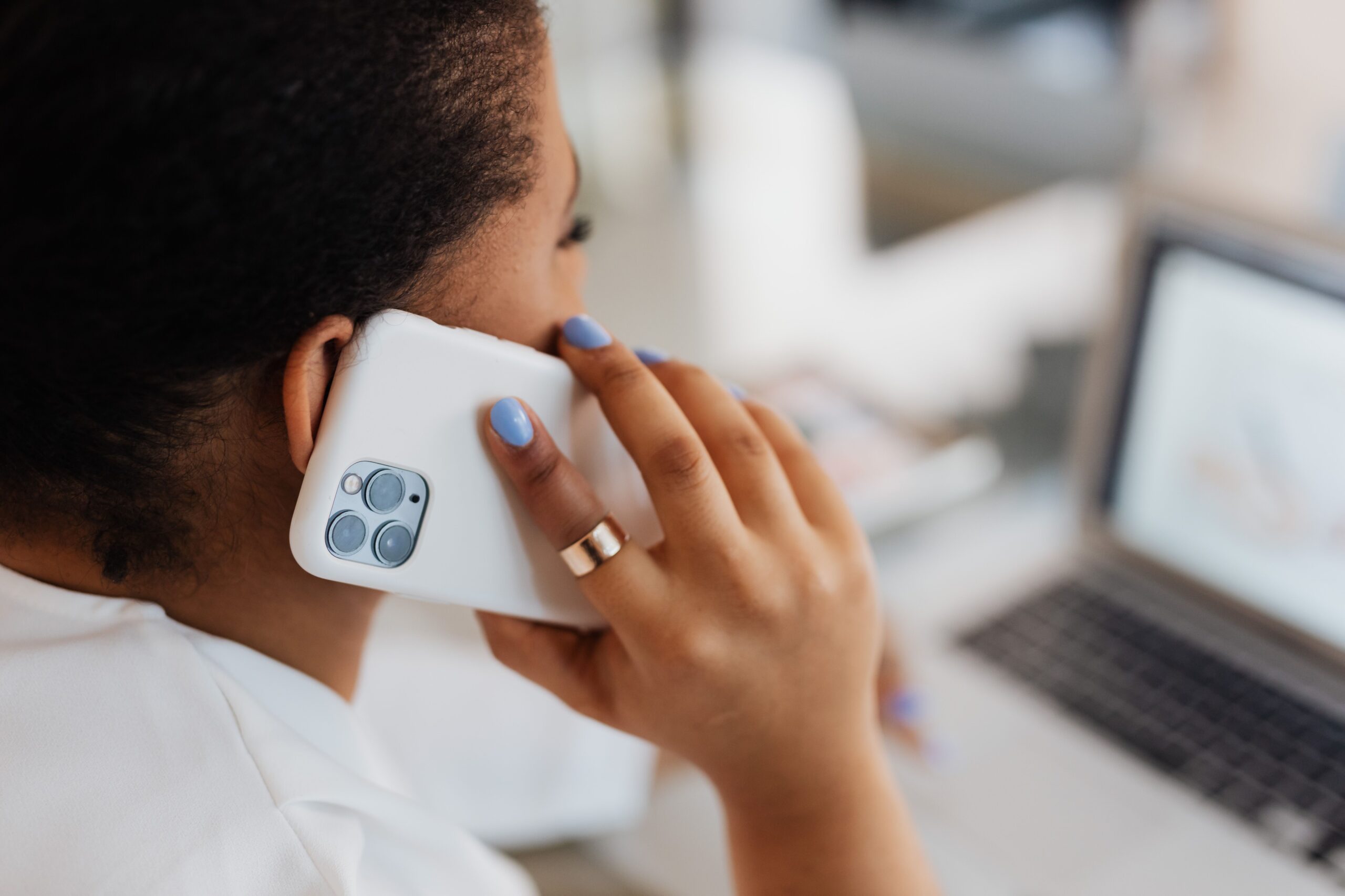 Frau im Telefonat mit Handy am Ohr